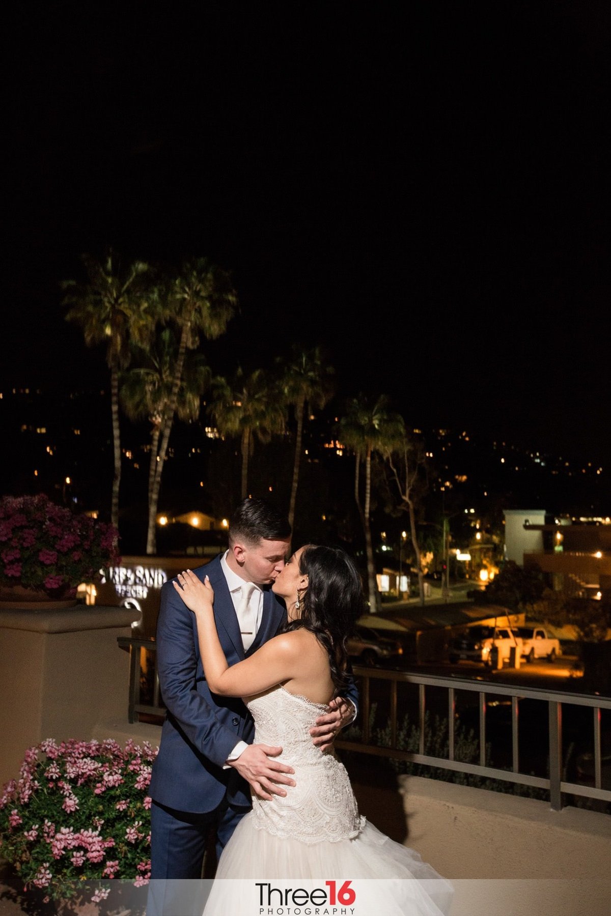 Passionate kiss shared by the Bride and Groom at night under the stars on the Surf and Sand Resort balcony