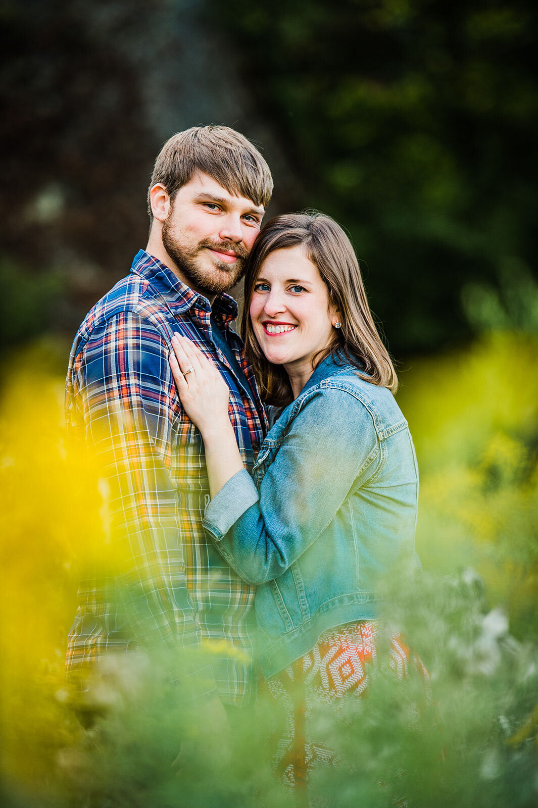 engaged couple in field with yellow flowers vermont