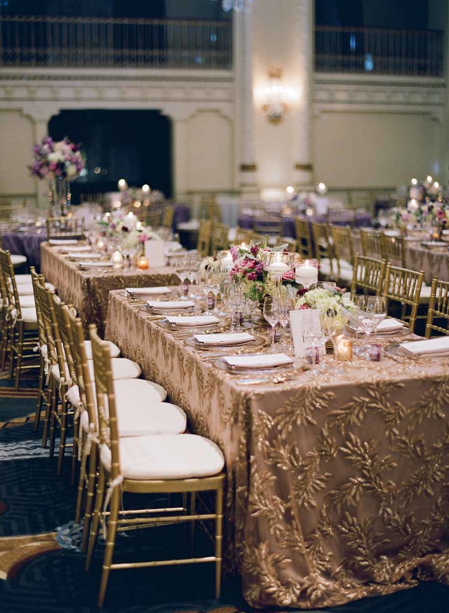 Long tables with gold linens and chiavari chairs complement the purple flowers for this Seattle wedding reception.