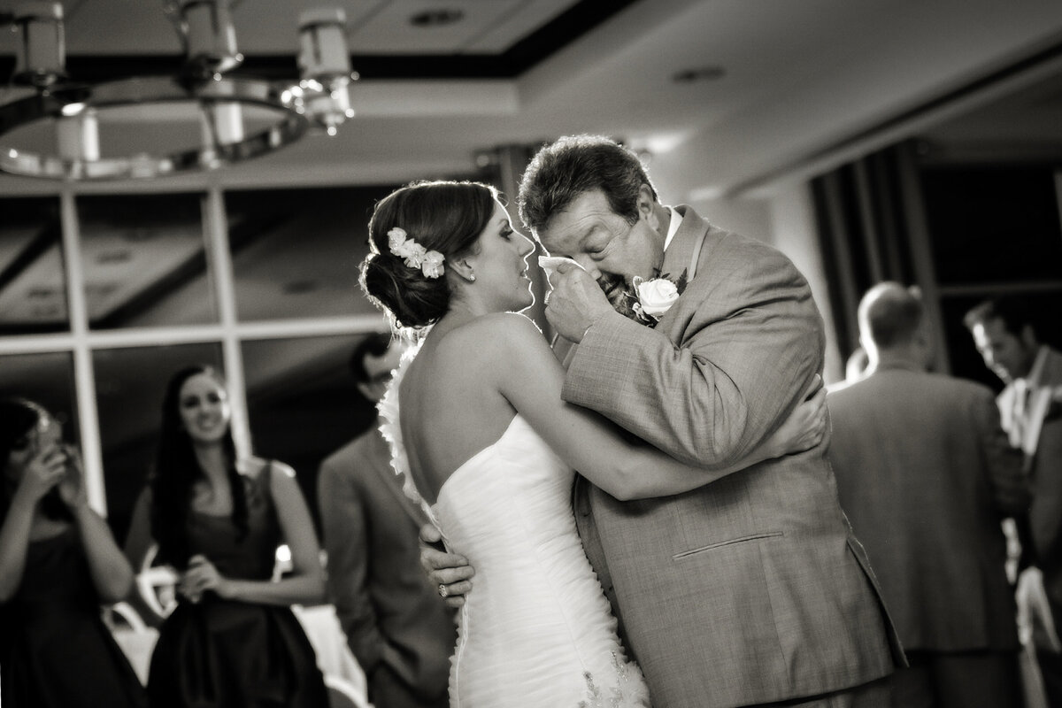 Dad crying during father daughter dance at wedding reception.