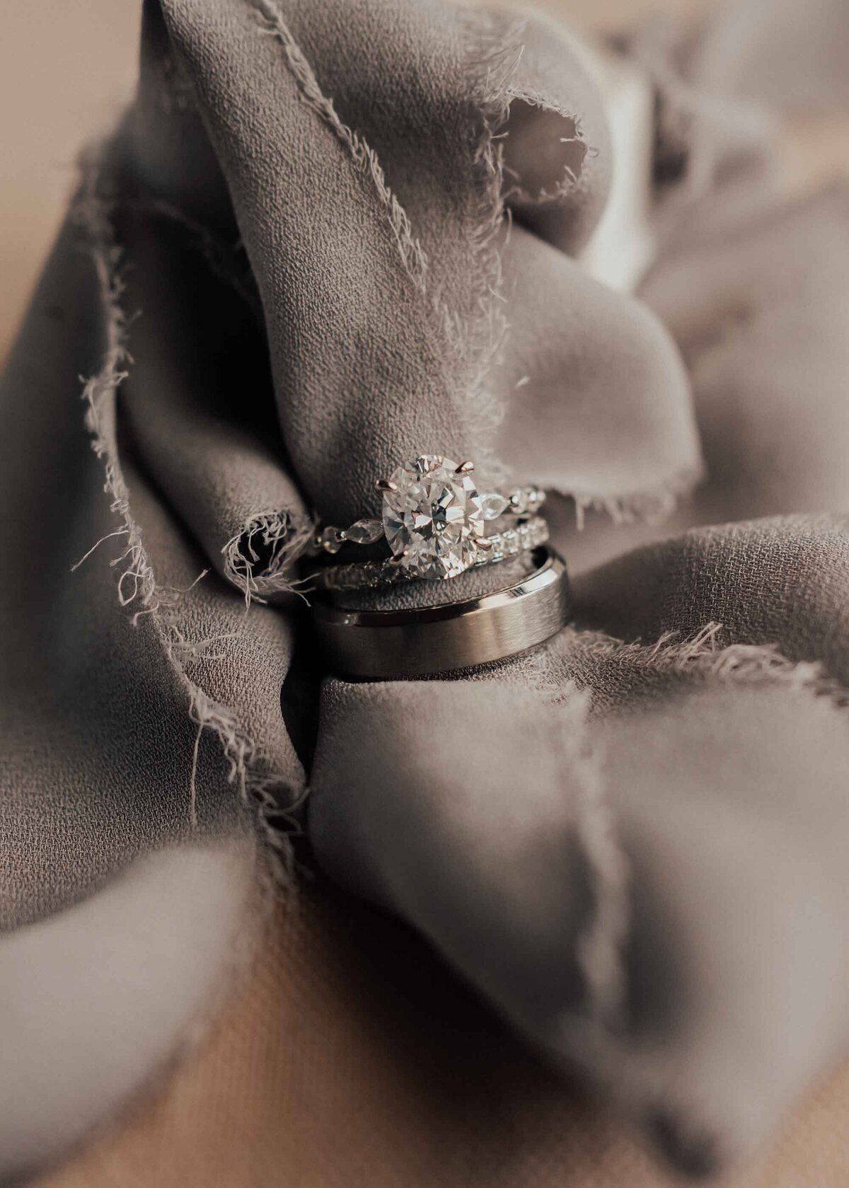 Maddie Rae Photography up close of the bride and grooms rings looped onto some ribbon