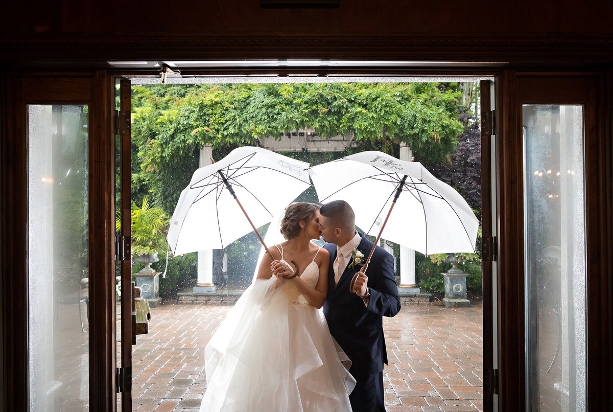 bride-groom-kissing-under-umbrella-nj-marlboro