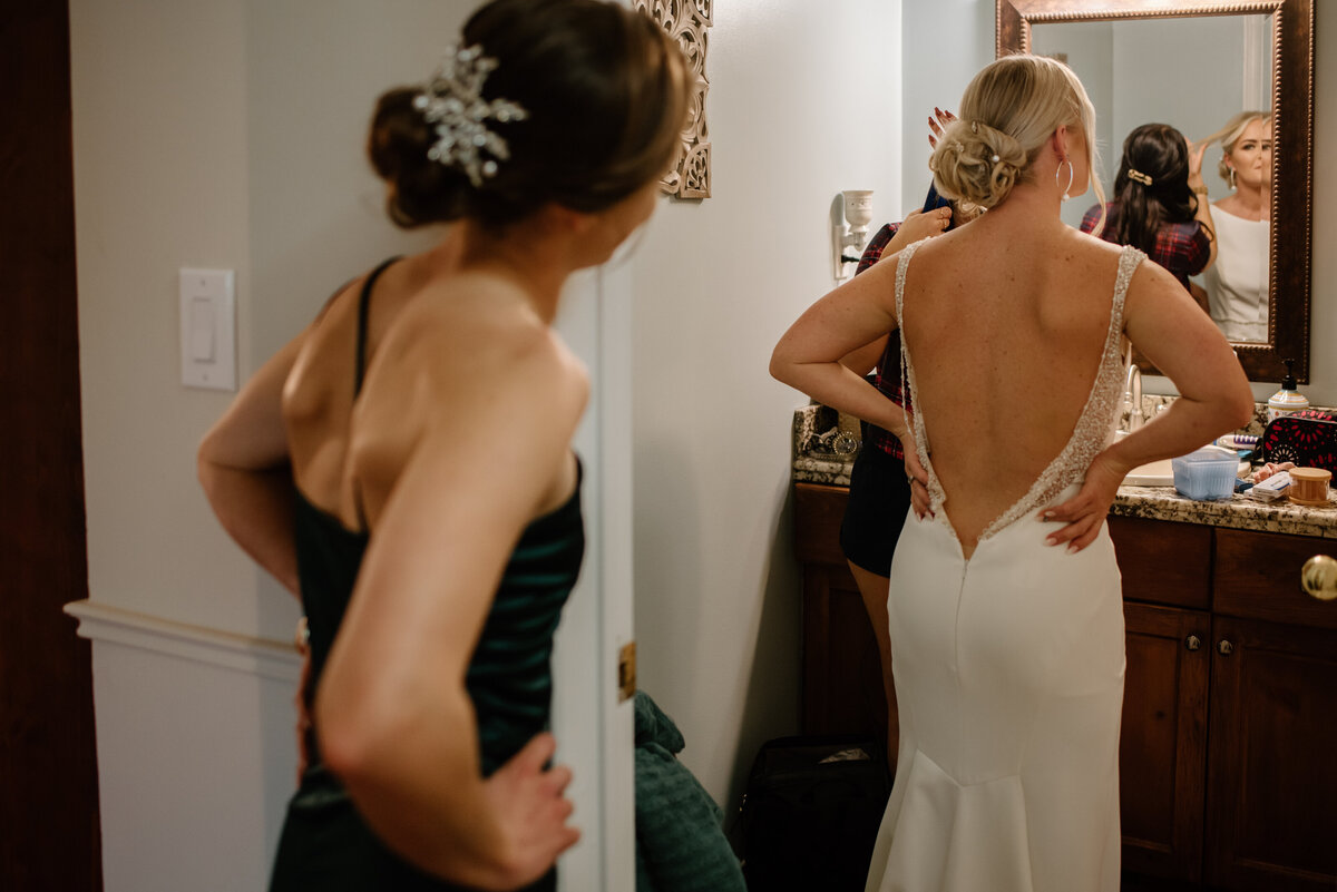 sisters looking into mirror before wedding