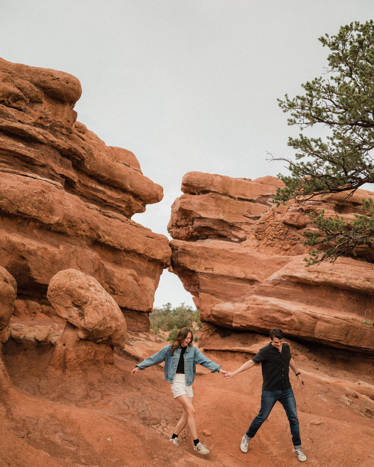 Couple holding hands surrounded by red rocks