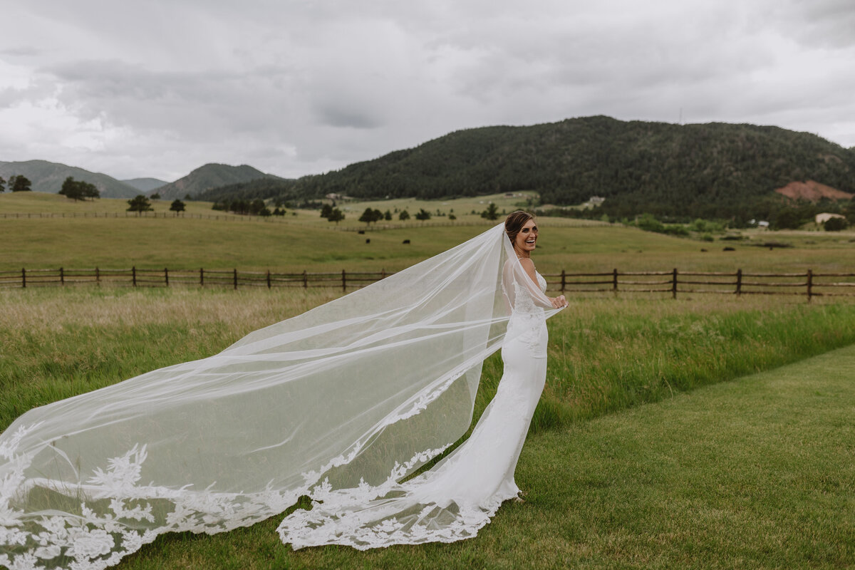 bride with long veil in field