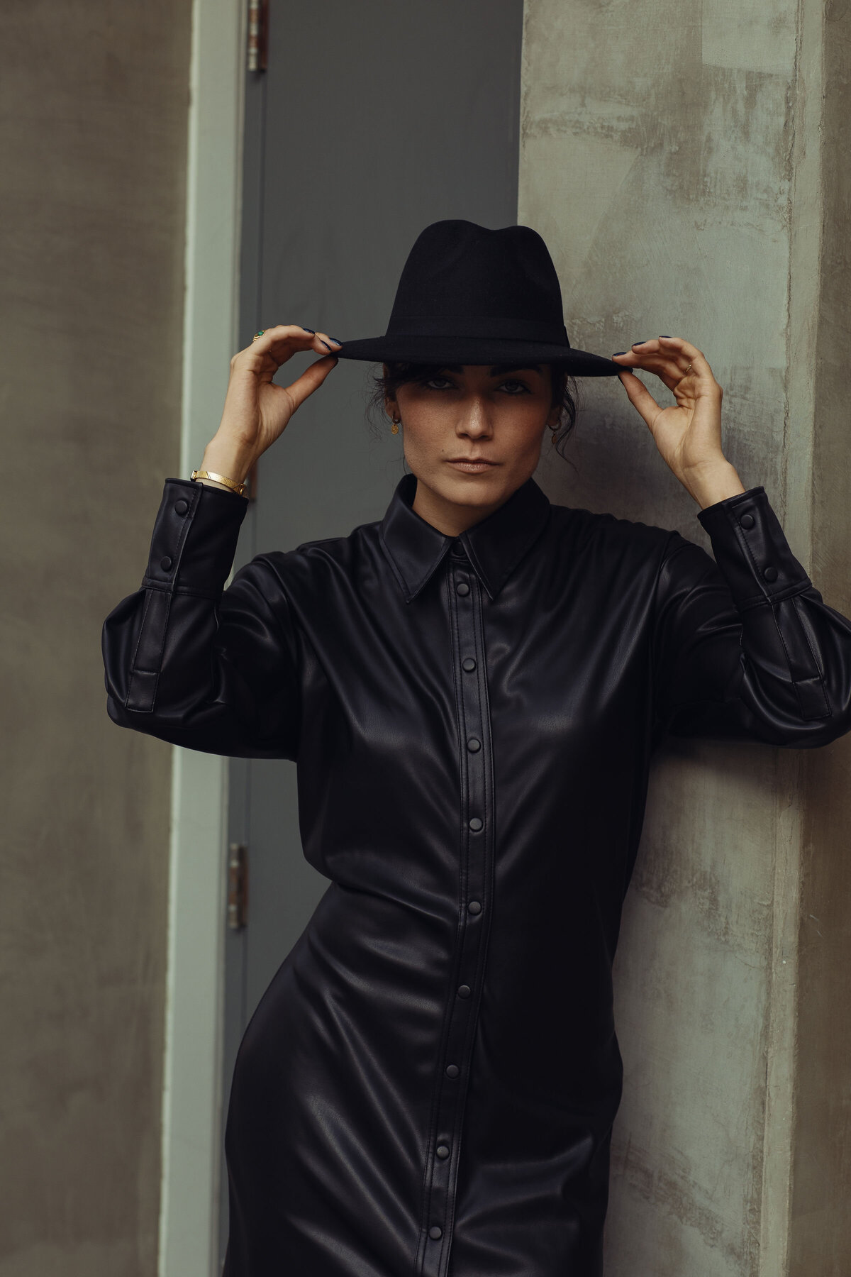 Portrait Photo Of Young Woman With Both Hands Touching Her Black Hat Los Angeles