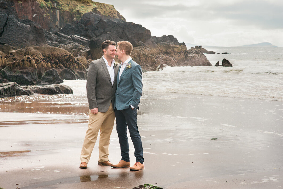 Gay wedding grooms kissing on the beach
