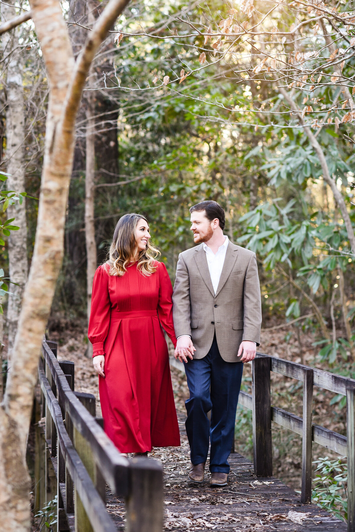 Beautiful Mississippi Engagement Photography: couple walks hand in hand over old bridge at sunset