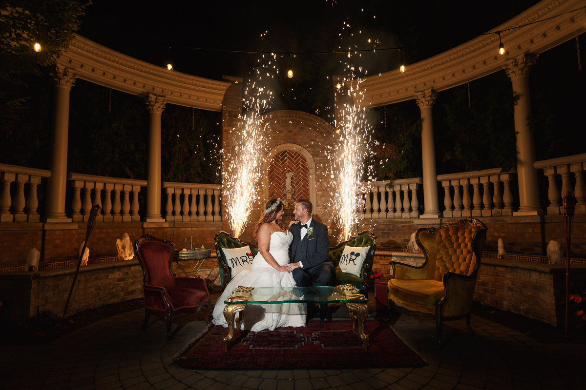 The Brownstone Wedding Couple on Patio with Large Sparklers Behind Them