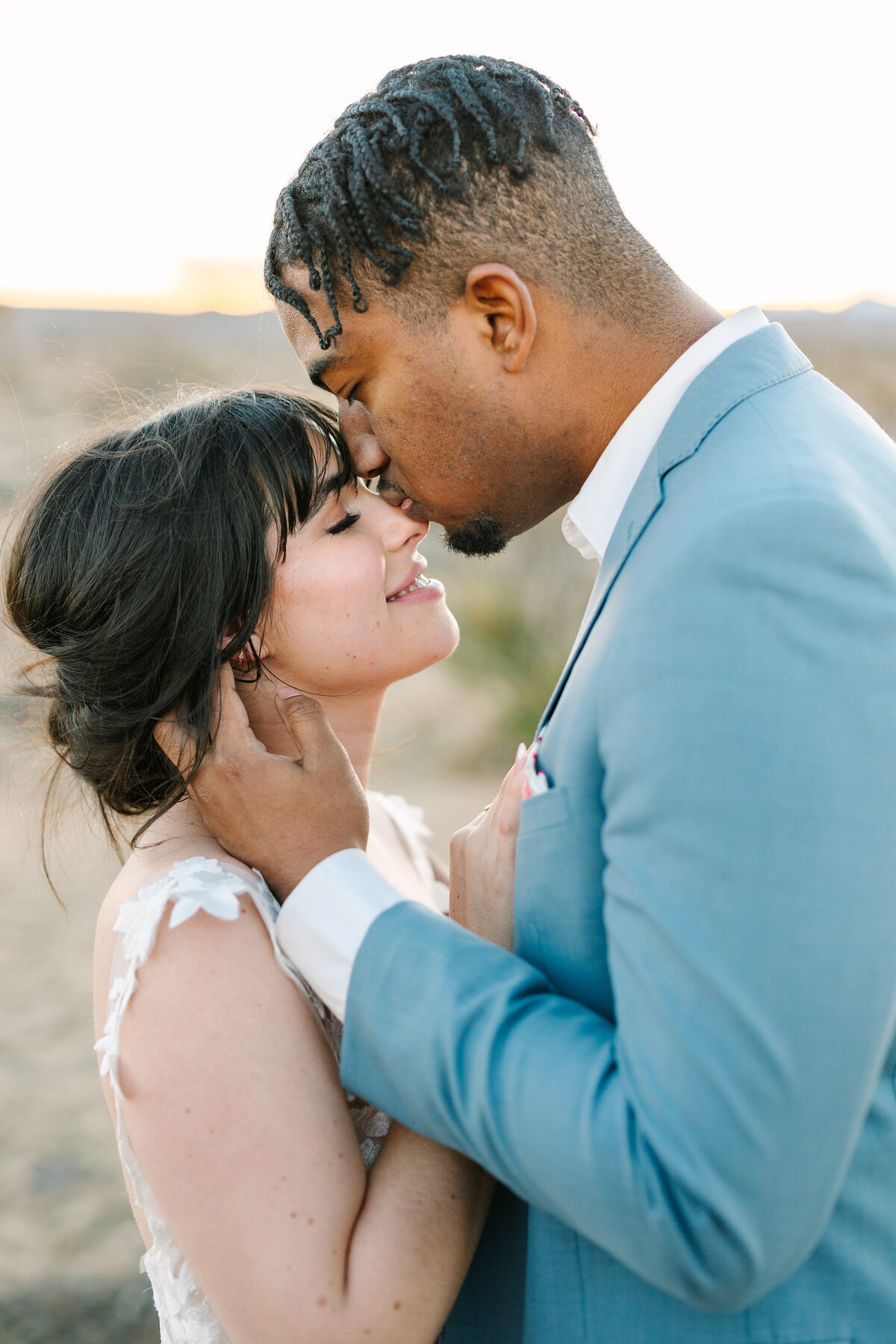 close up shot of groom softly kissing bride's nose in sonoma vineyard.