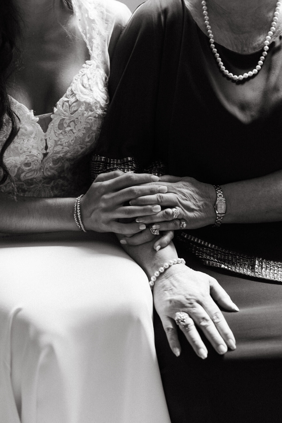 Bride holding hands with her elderly grandmother on her wedding day