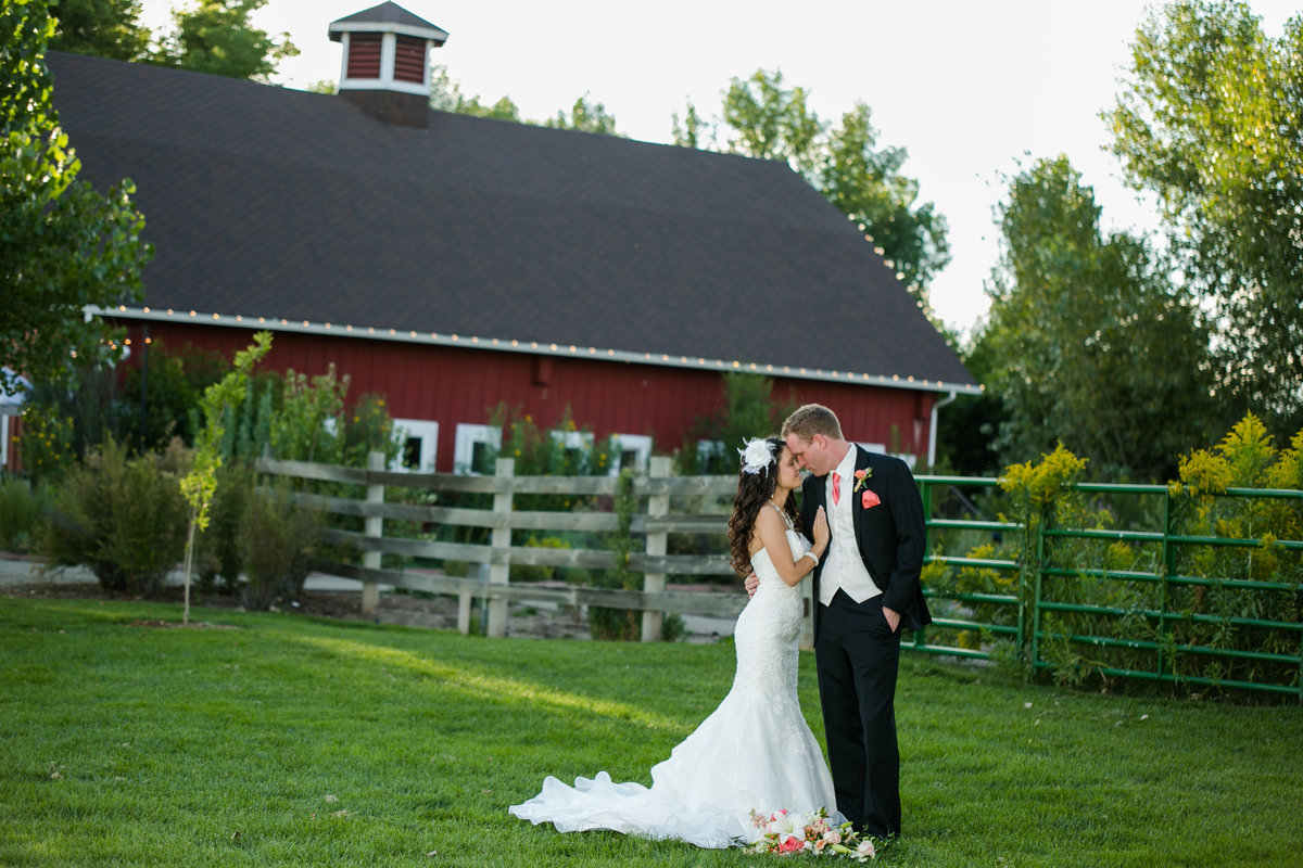 wedding couple in front of big red barn