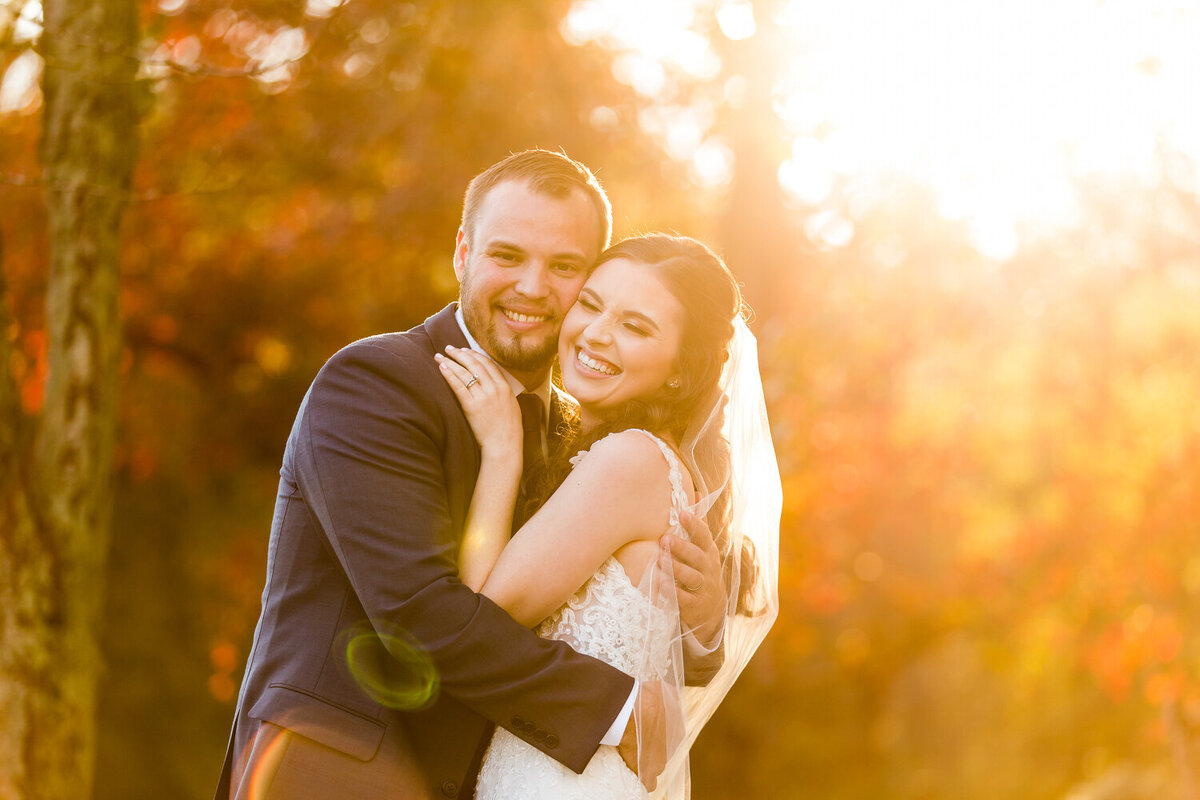 joyful wedding couple during sunset golden hour in the fall