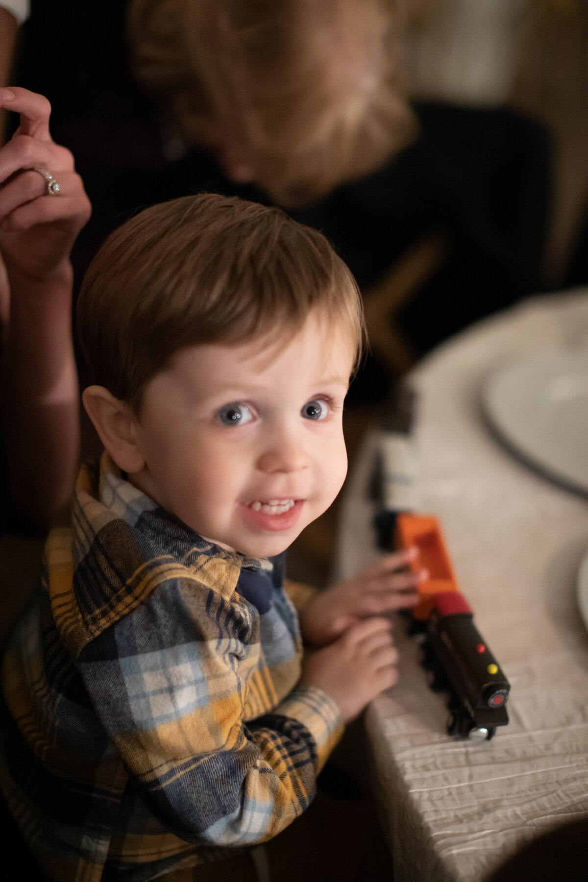 little boy plays with trains during wedding reception