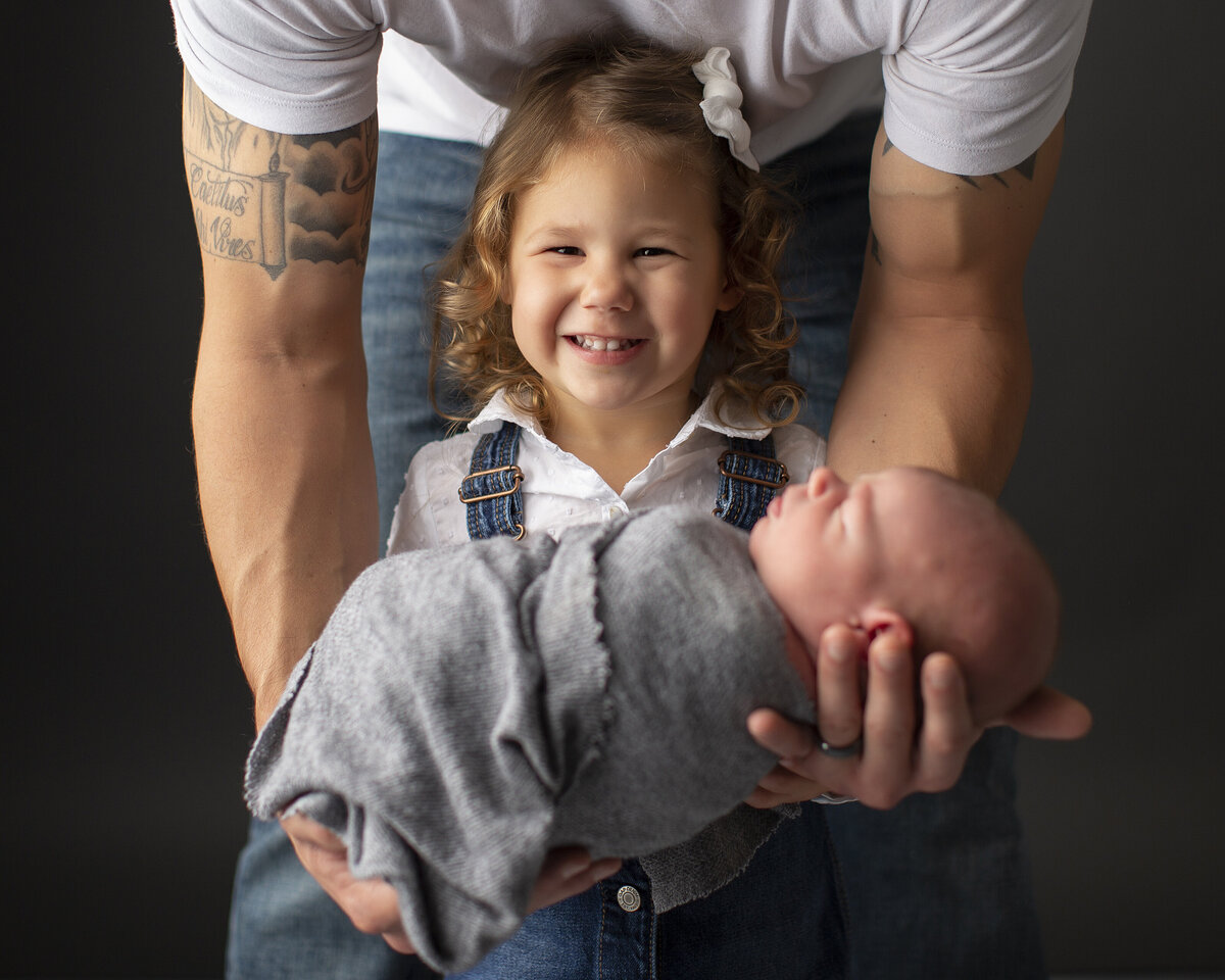 Big sister holding baby brother in studio portrait located in Greensburg studio