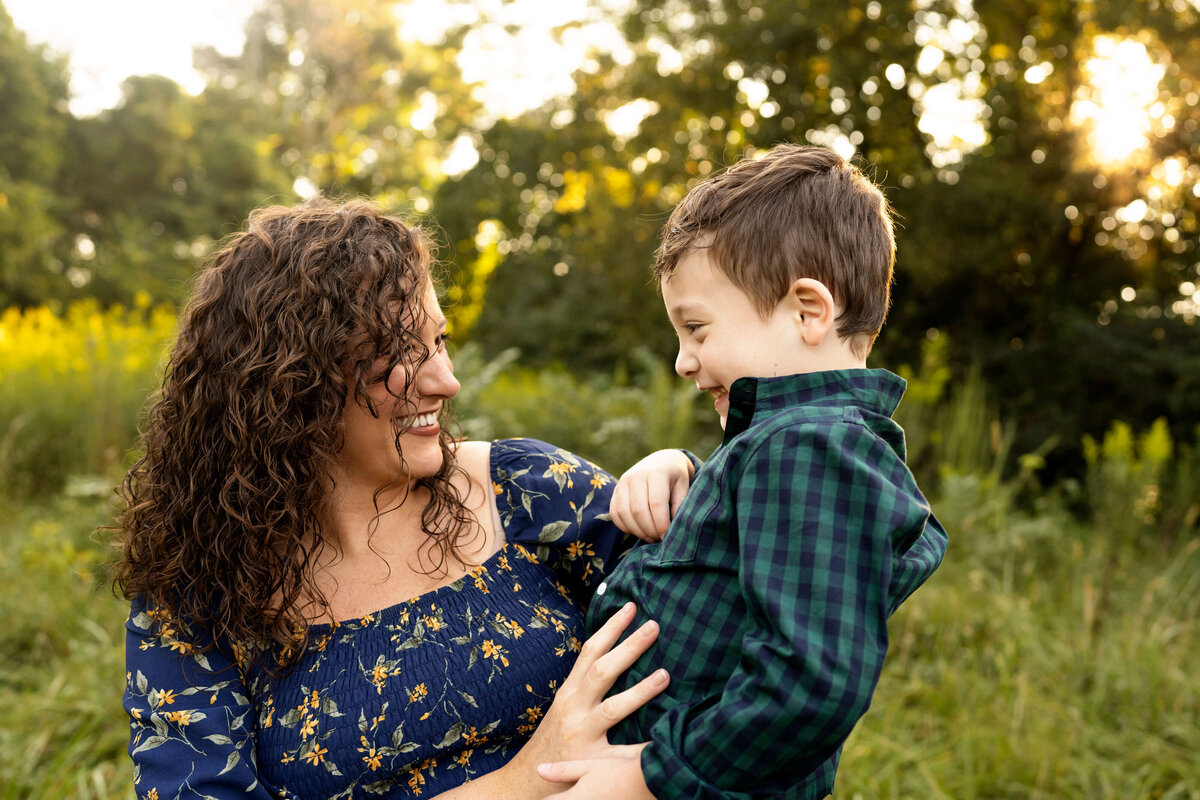 Mother holding young son while smiling at each other by  atlanta family photographer