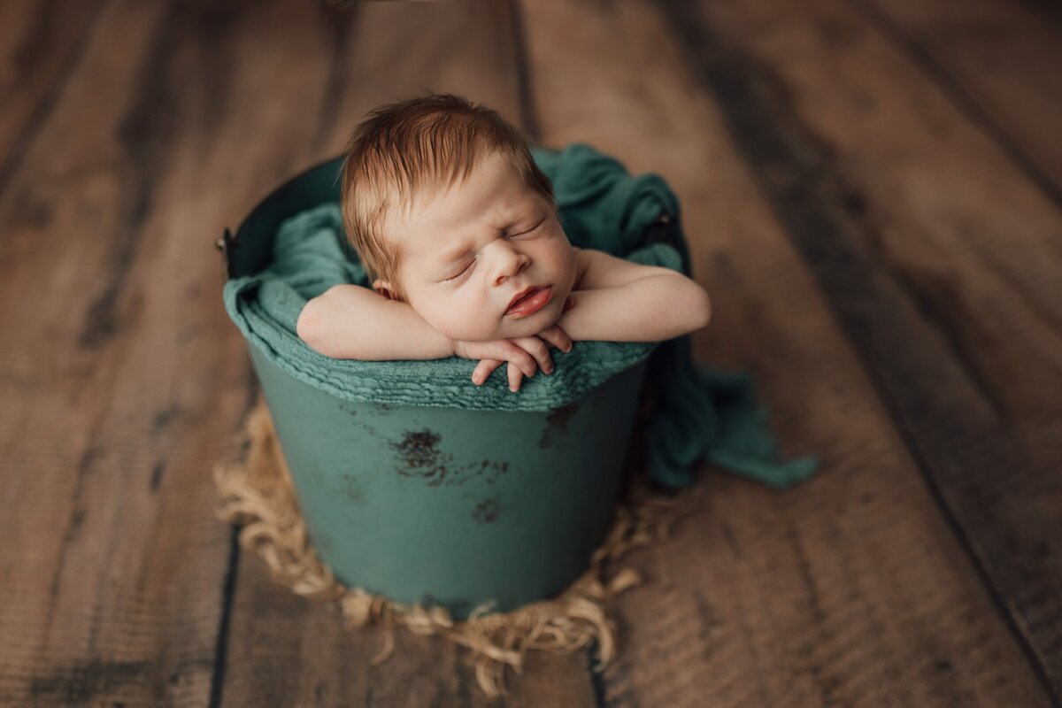 baby boy in bucket during newborn session in Tampa