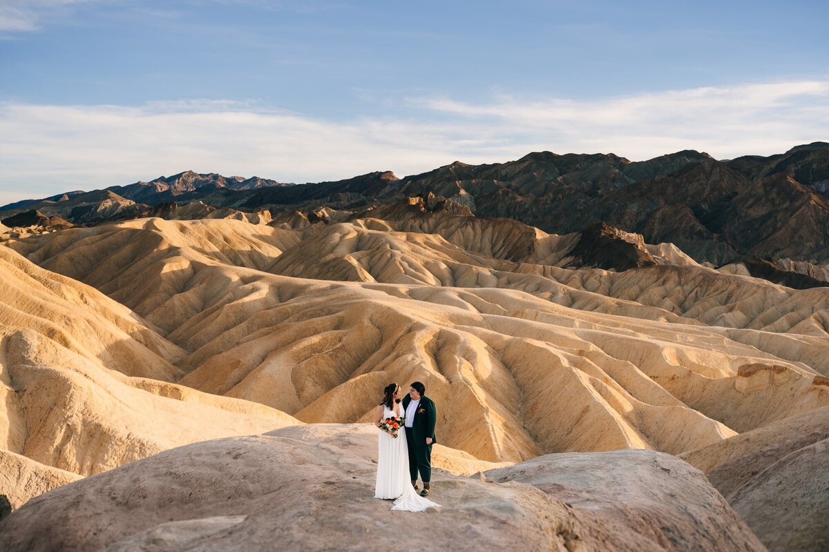 A stunning elopement photo at Zabriskie Point in Death Valley National Park, capturing the essence of love amidst the dramatic desert landscape.