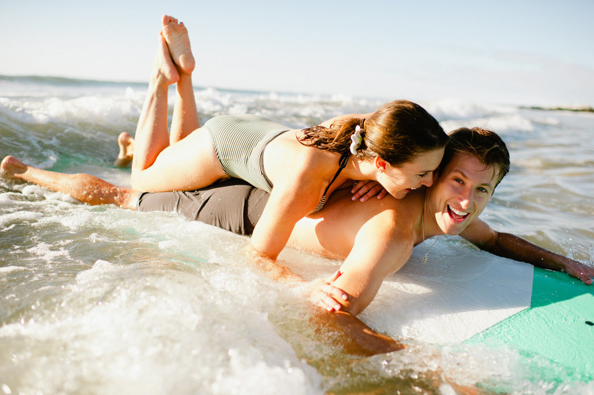 happy couple playing in the surf lifestyle photography