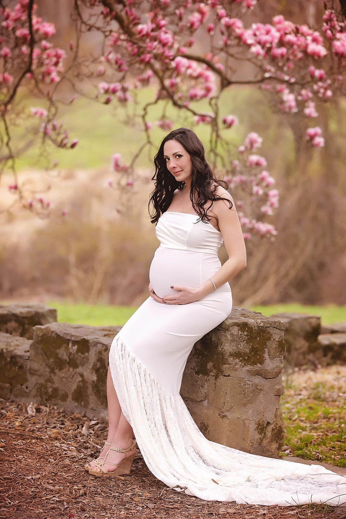 beautiful expecting mom wearing a long lacy cream dress