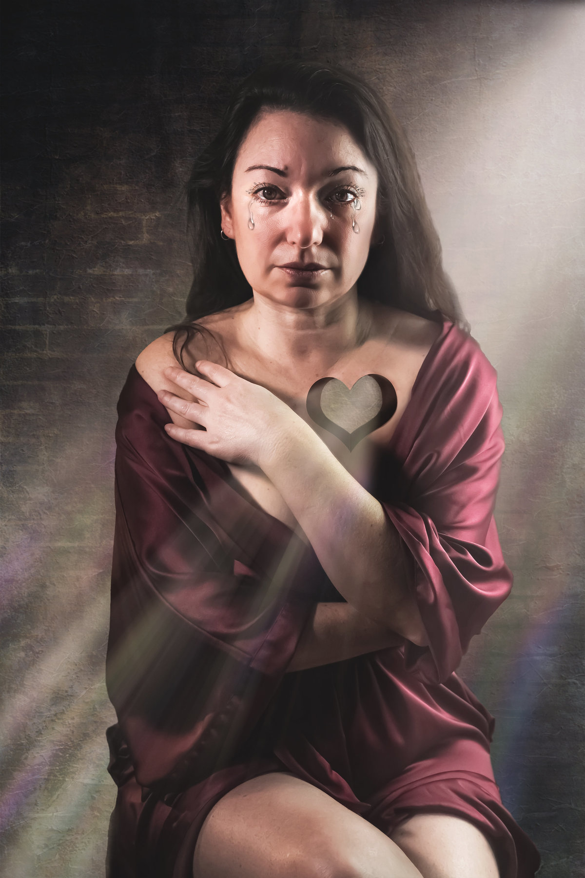 Creative portrait of a woman with a heart shaped hole in her chest.