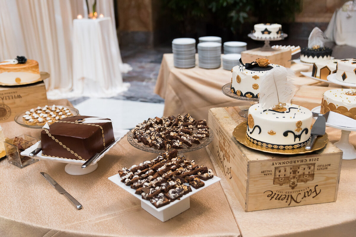 wedding table that has desserts, cakes, cupcakes and brownies