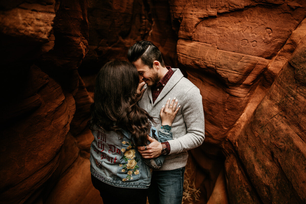 man and woman holding each other in red rock canyon