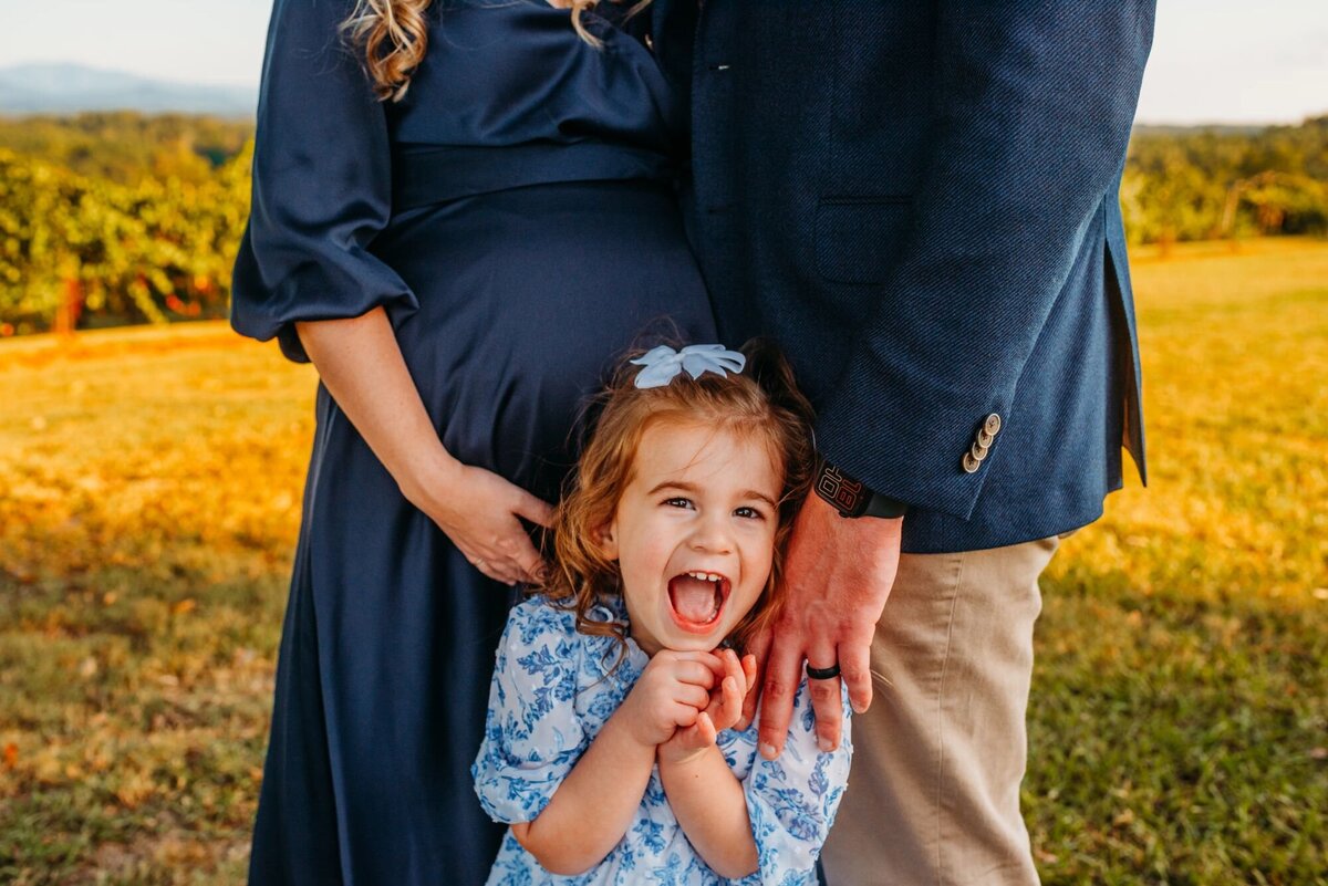 photo of girl laughing by her parents