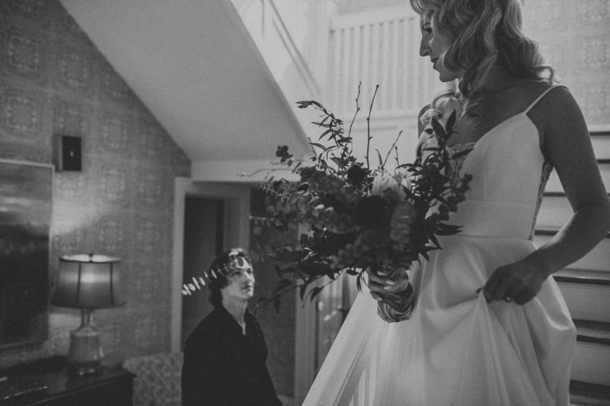 Wedding Photographer, black and white of bride walking down the stairs looking at groom
