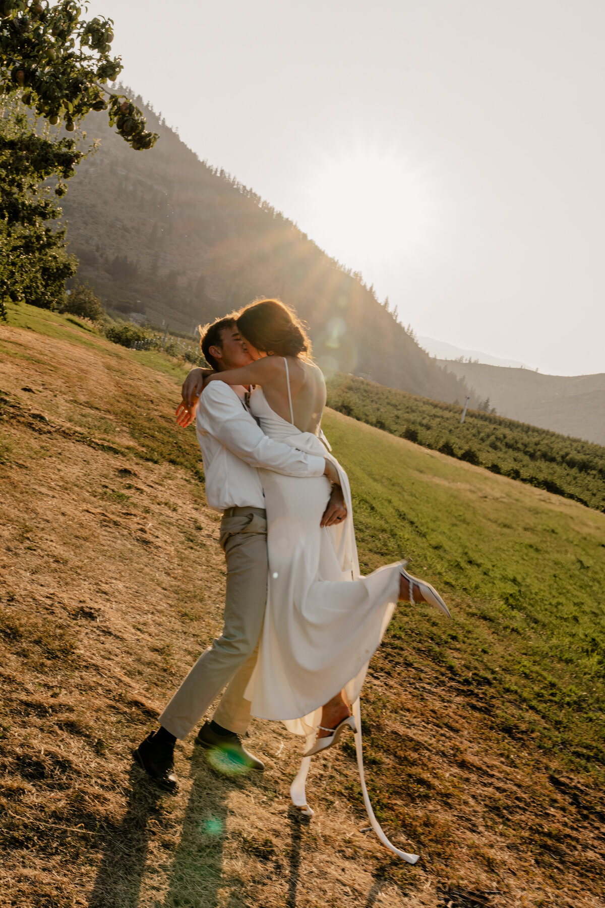 Jake and Sophie kiss passionately in the sunset during their wedding at the Barn on Hinman in Cashmere, Washington.