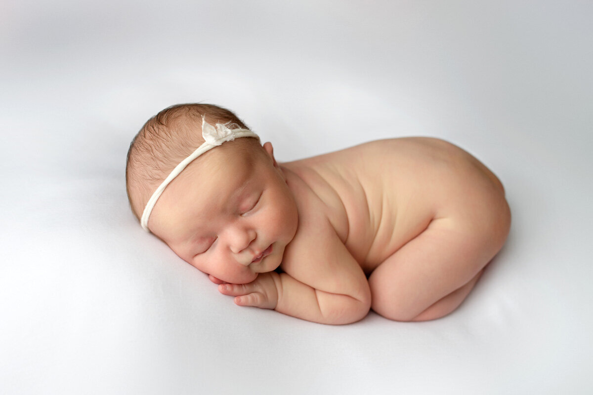 Newborn session of baby girl wearing a bow