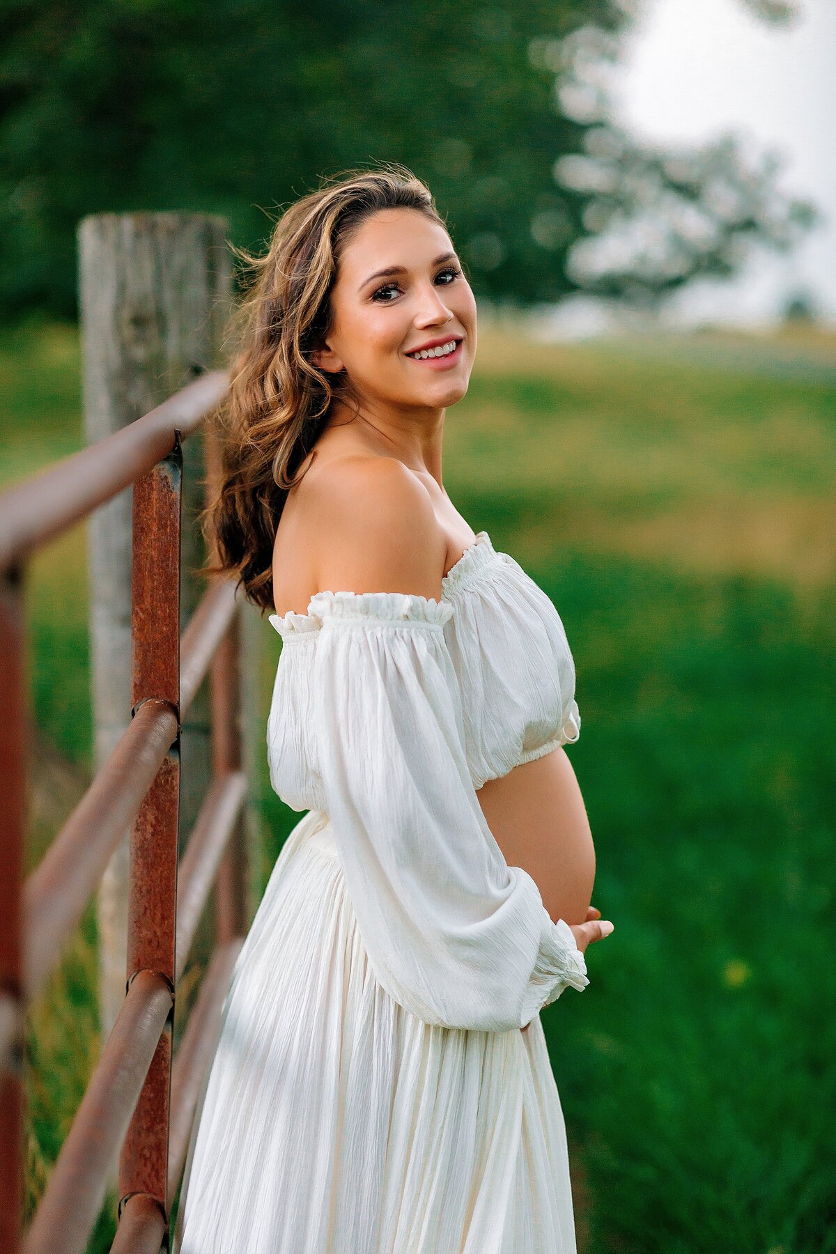 Pregnant woman in a field in a white dress Harrisonburg VA