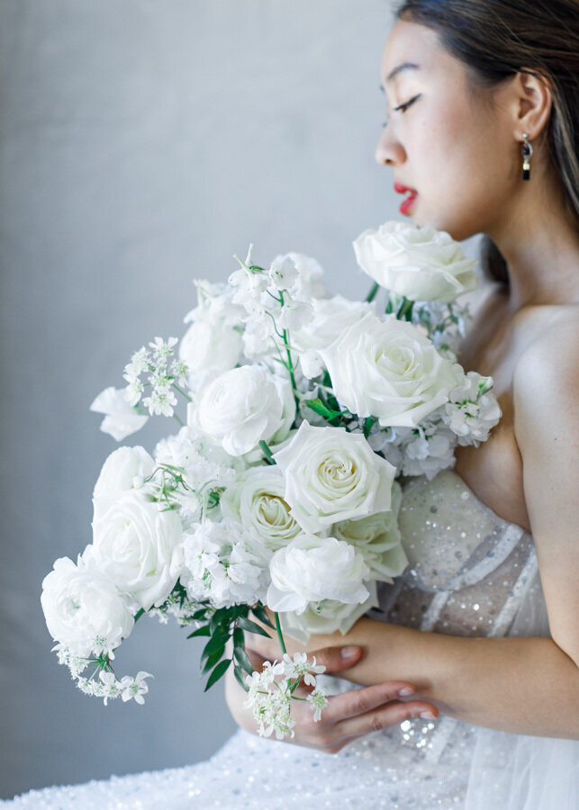 Gorgeous wedding photography of a bride in a wedding dress holding a white bouquet.