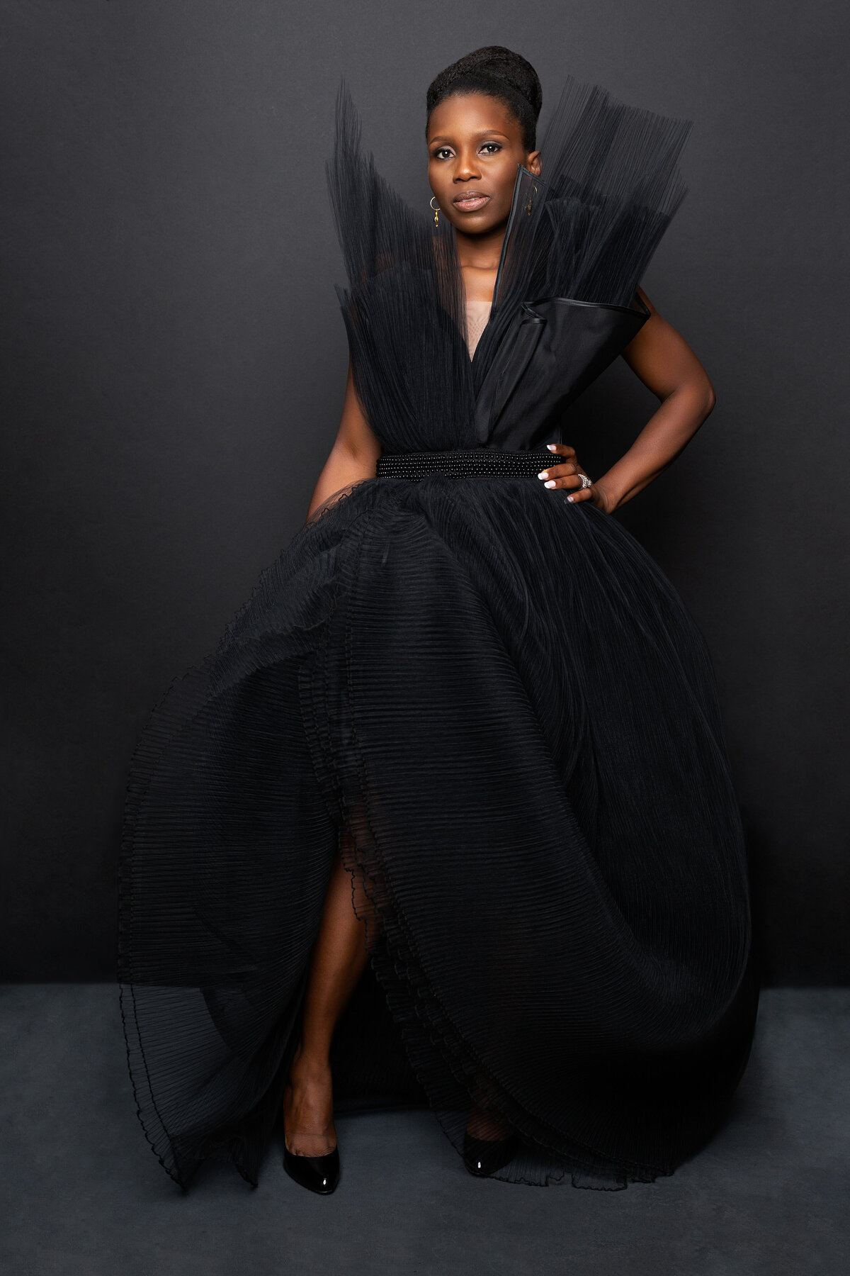 A beautiful black Nigerian African American woman in a black designer dress poses for a portrait at Janel Lee Photography Studios Cincinnati Ohio Oakley area
