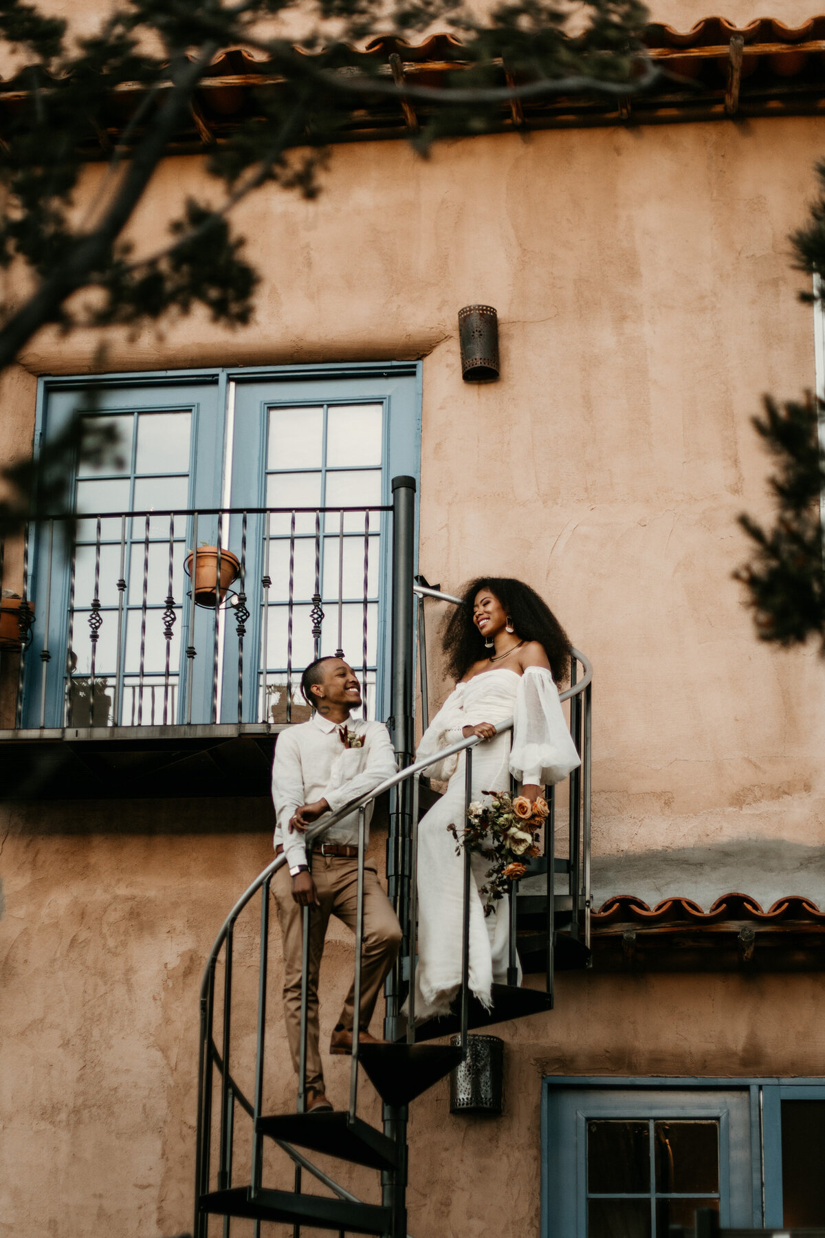 Bride and groom standing on a spiral staircase in Santa Fe venue