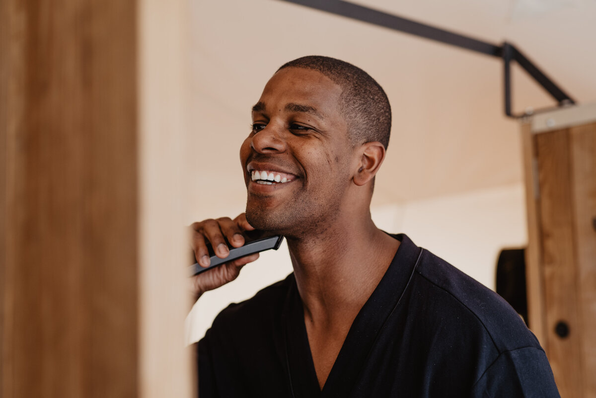 Utah Elopement Photographer captures groom smiling while shaving