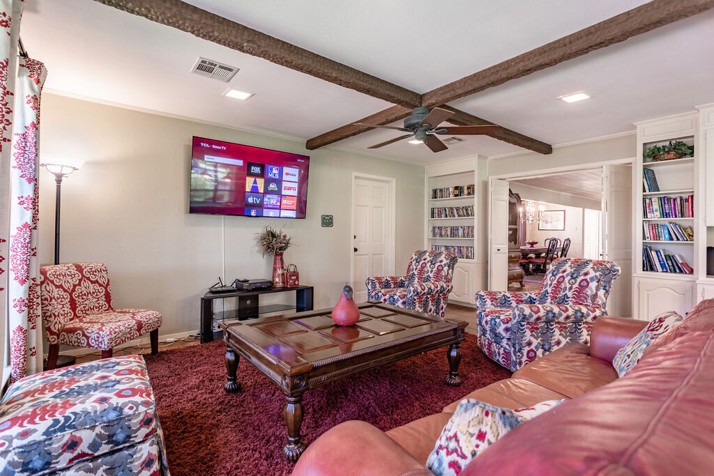 Living room with smart TV and plenty of comfortable seating in this 5-bedroom, 4-bathroom vacation rental house for 16+ guests with pool, free wifi, guesthouse and game room just 20 minutes away from downtown Waco, TX.