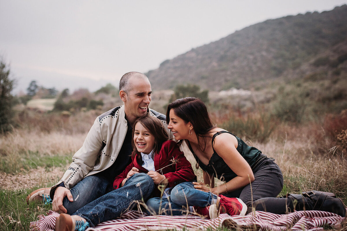 Family of three sits on blanket on Pasadena hillside