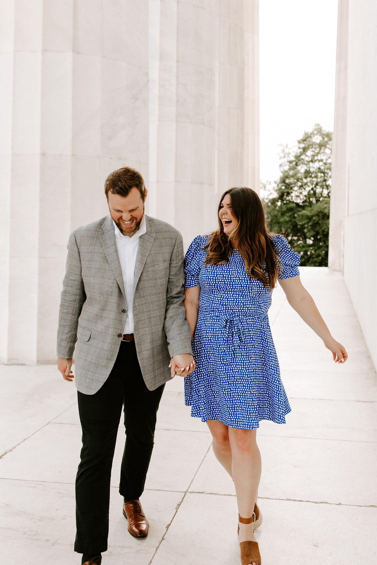 A male and female walking in a DC monument, standing hand in hand while smiling at eachother