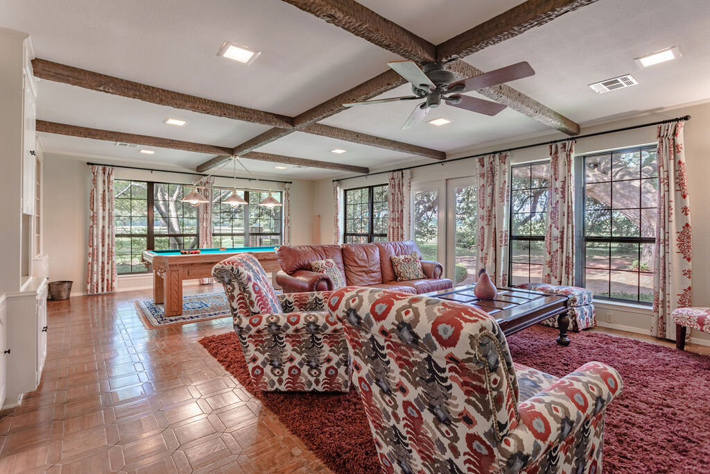Large living room with smart TV and comfortable seating and pool table in this 5-bedroom, 4-bathroom vacation rental house for 16+ guests with pool, free wifi, guesthouse and game room just 20 minutes away from downtown Waco, TX.