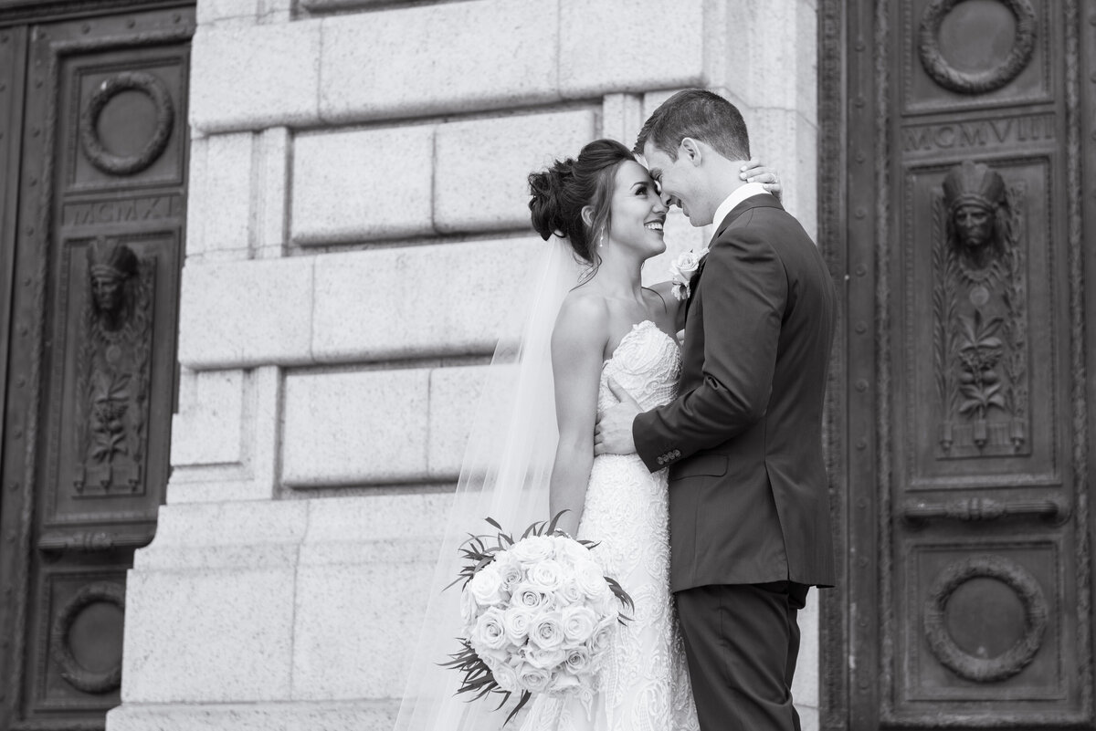 Bride and groom embrace each other happily on their wedding day, behind The Old Courthouse located in Ohio. Photo taken by Columbus Wedding Photographer Aaron Aldhizer