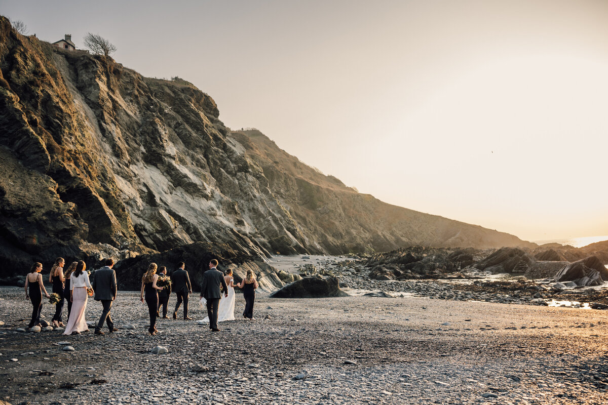 Bridal party walking on sea shore in the United Kingdom