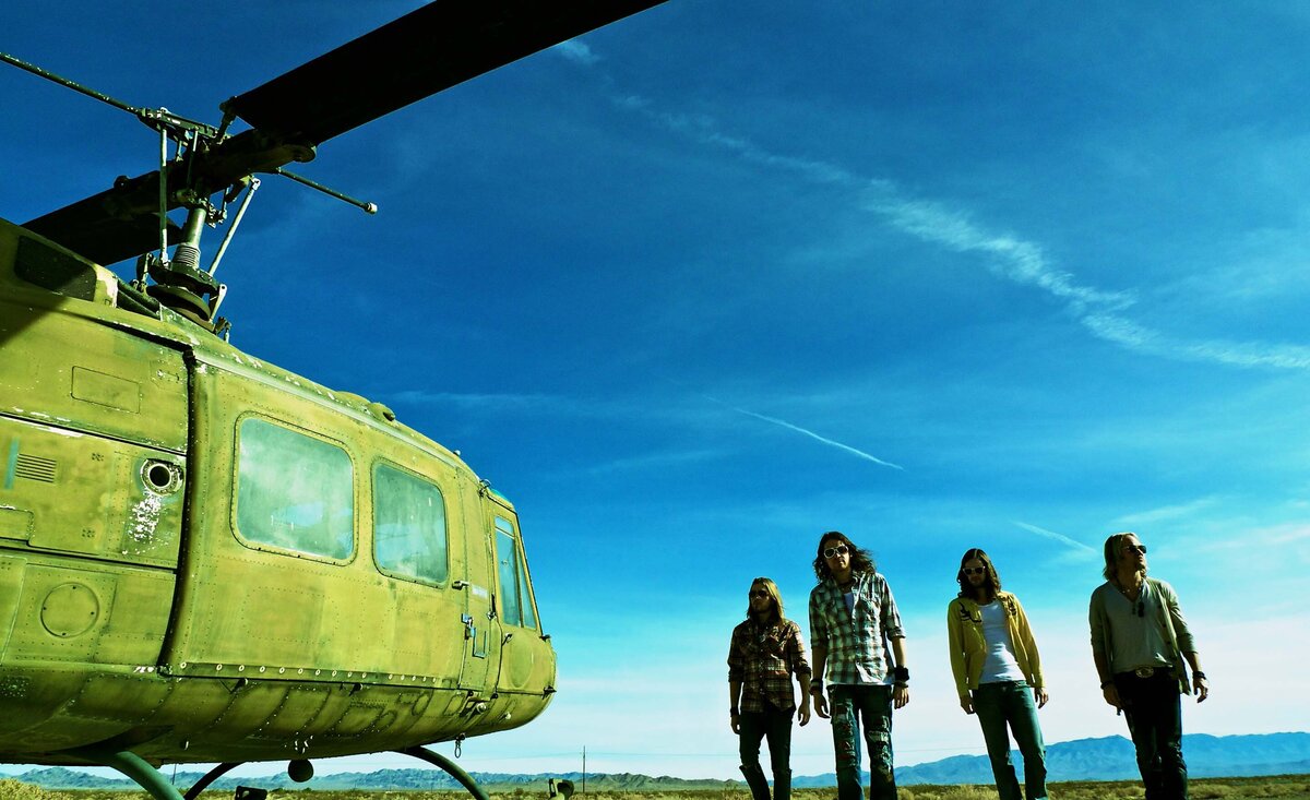 Rock band portrait walking beside helicopter