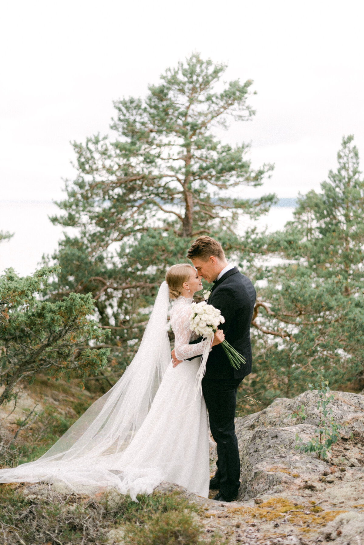 Image of a wedding couple in the forest by the sea photographed by wedding photographer Hannika Gabielsson.
