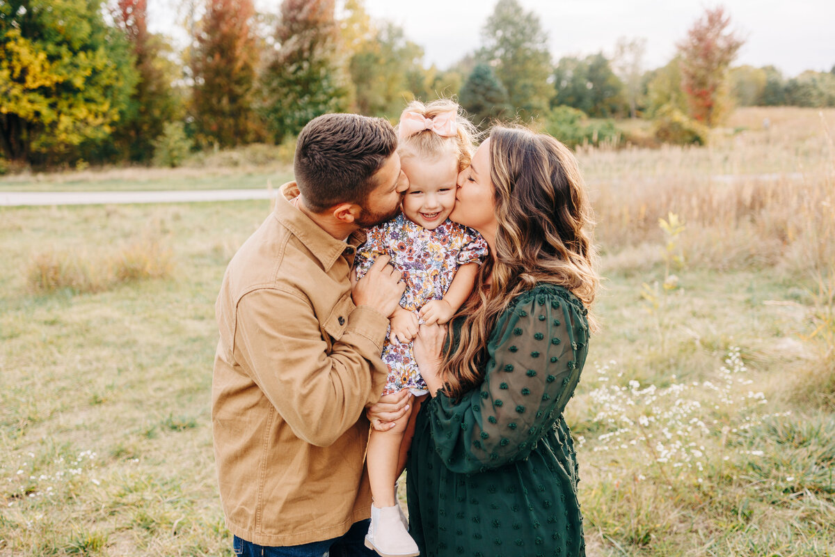 parents kissing their toddler during their photo session