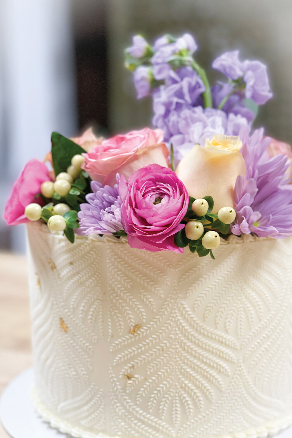 Close-up of intricate lace detailing on a pink and yellow girl baby shower cake, highlighting the elegant and delicate design elements of the confection.