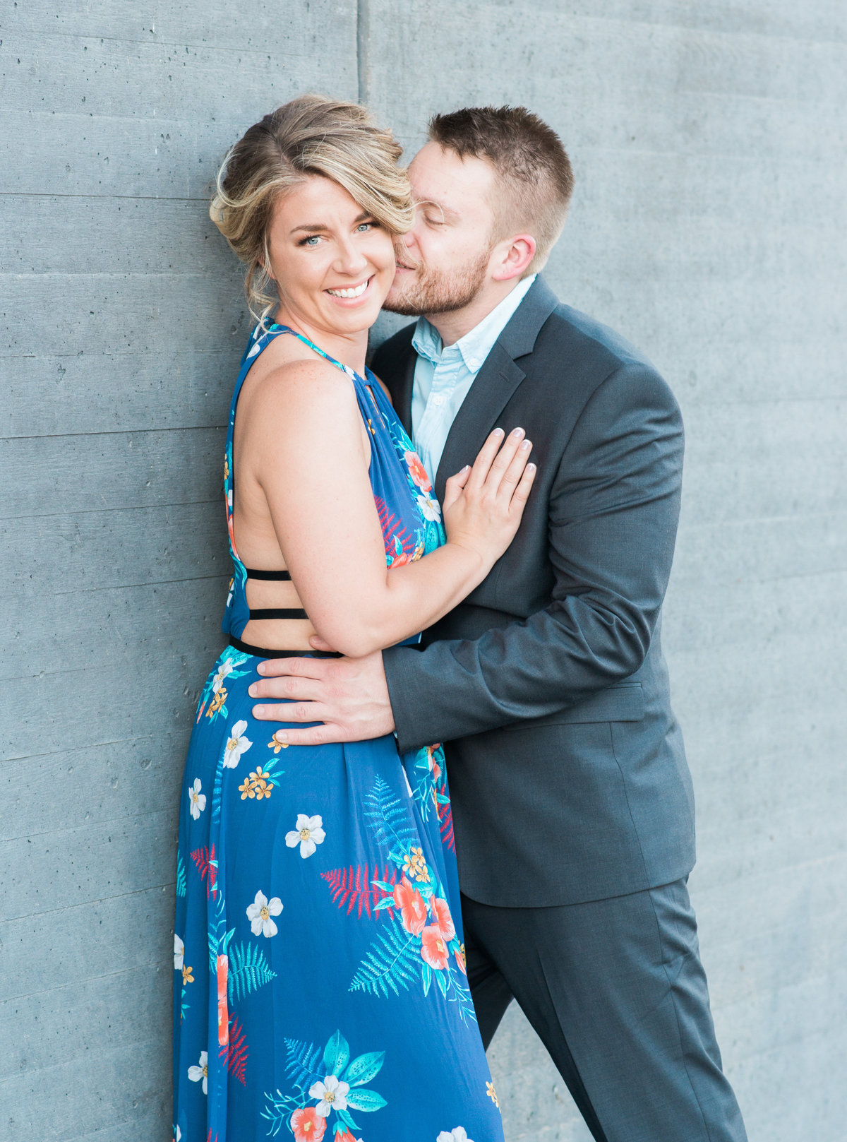 Couple outdoors at the Figge Art Museum in downtown davenport for engagement pictures wearing a blue suit and a dress from Express