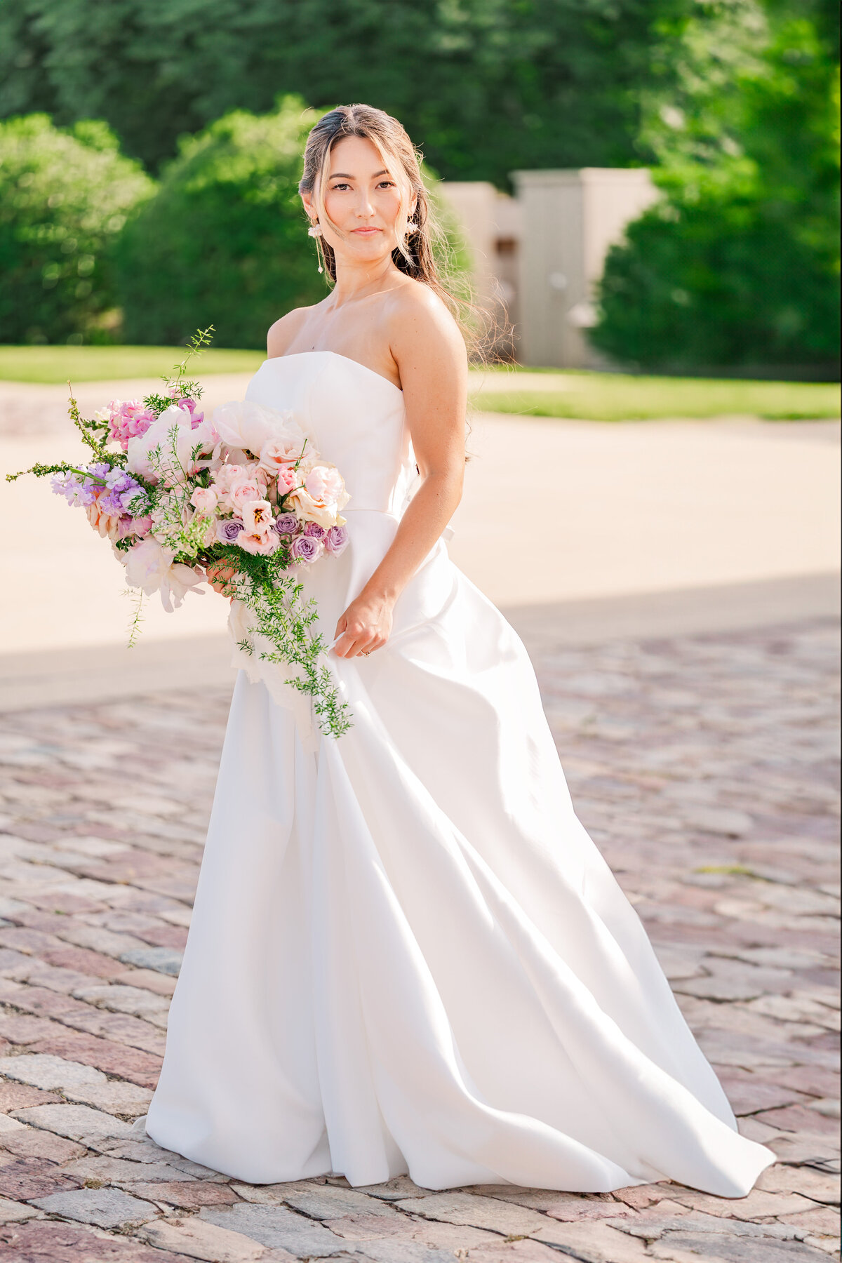 A brunette bride having her Raleigh wedding bridal portrait session at The Oxbow Estate courtyard in the summer