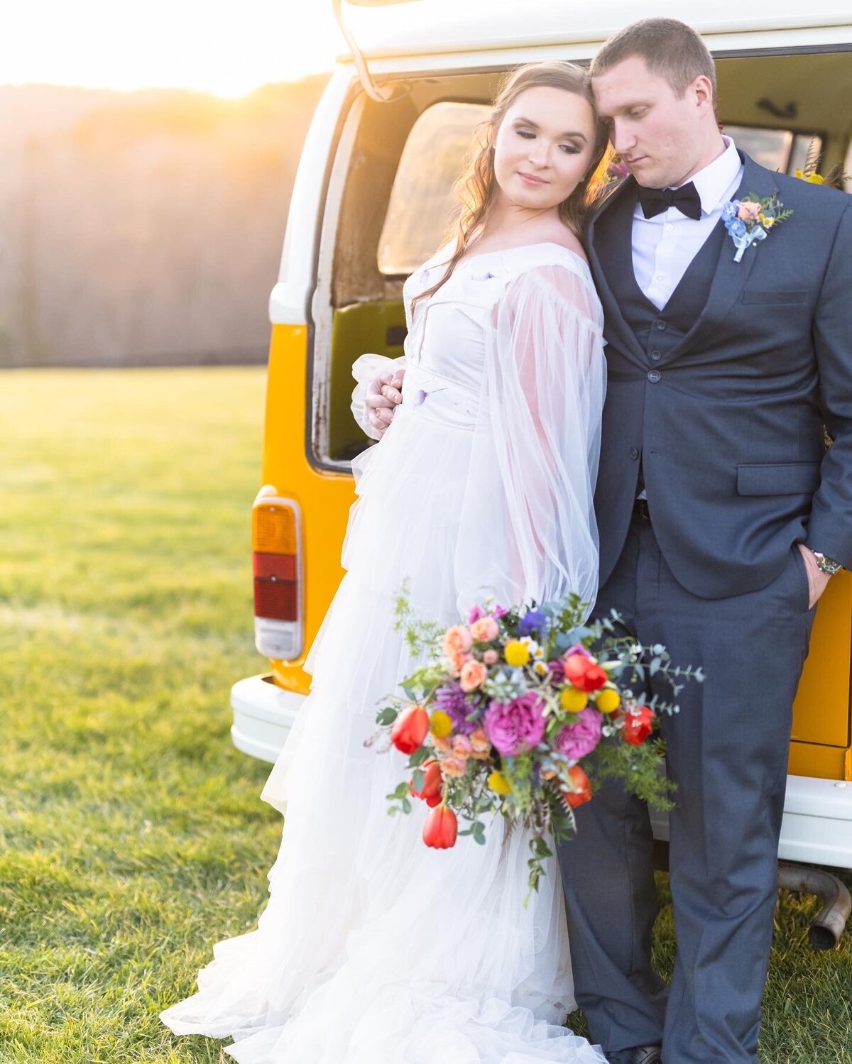 bride and groom standing in front of van