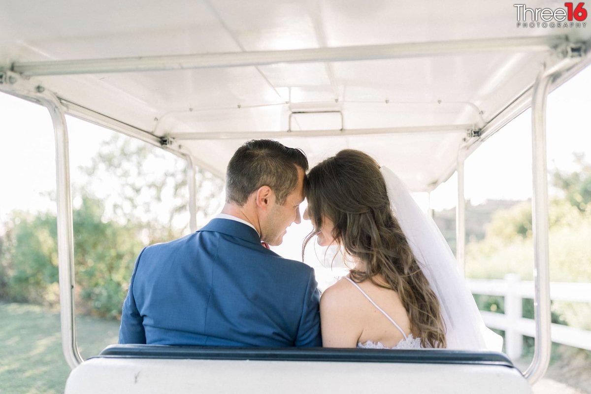 Tender moment between Bride and Groom in a golf cart